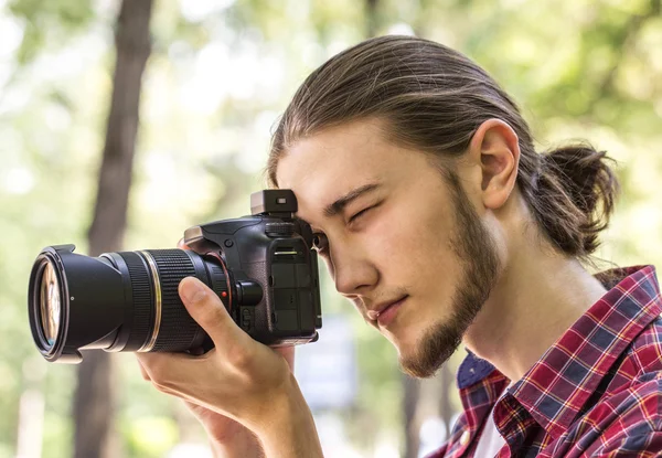 Fotografo maschio che scatta foto con fotocamera DSLR . — Foto Stock