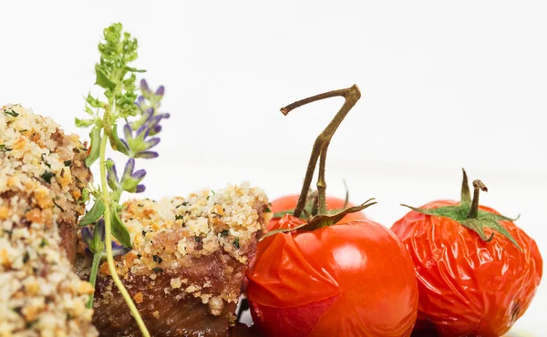 Paniertes Schweinefilet mit Tomaten-Confit. — Stockfoto