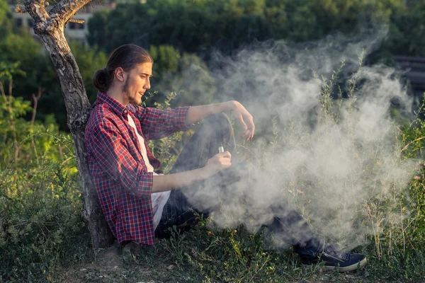 Bello giovane uomo fumare sigaretta elettronica . — Foto Stock