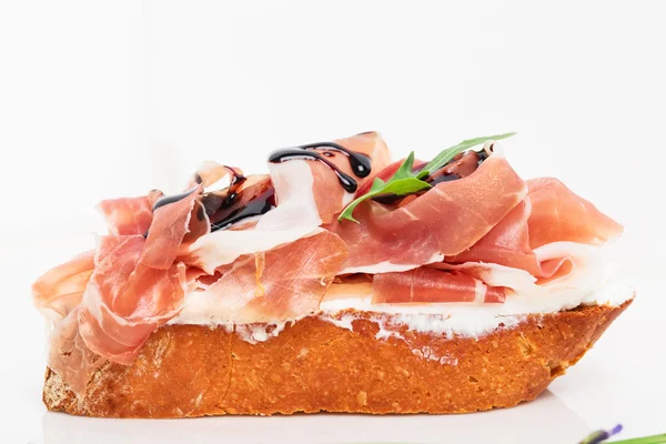 Prosciutto bruschetta ricotta ve roka ile.