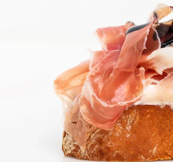 Prosciutto bruschetta s ricottou a rukolou. — Stock fotografie