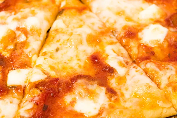 Close-up van gesmolten kaas op pizza gesneden. — Stockfoto