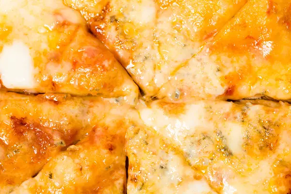 Nahaufnahme von geschmolzenem Käse auf aufgeschnittener Pizza. — Stockfoto