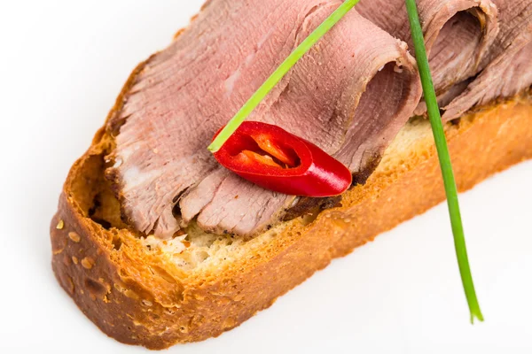 Delicioso bruschetta com rosbife e cebolinha . — Fotografia de Stock