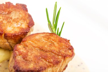 Kızarmış domuz eti bonfile madalyonlar hardal sosu üzerinde.