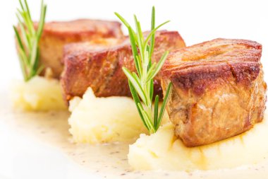 Kızarmış domuz eti bonfile madalyonlar patates püresi üzerinde.