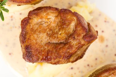 Kızarmış domuz eti bonfile madalyonlar hardal sosu üzerinde.