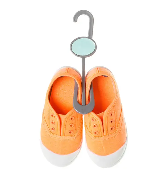 プラスチック ハンガーの赤ちゃん女の子オレンジ スニーカー. — ストック写真