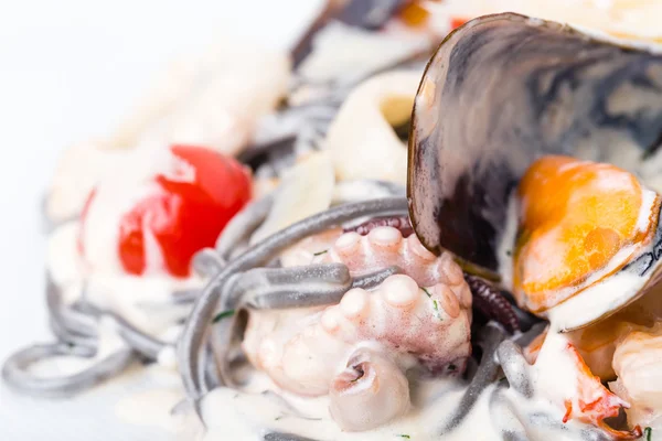 Pâtes noires aux fruits de mer en sauce crème . — Photo