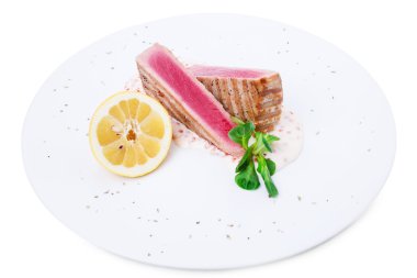 Izgara ton balığı filetosu sos ve limon ile.