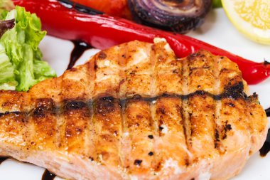 Kavrulmuş sebze ile ızgara somon fileto.