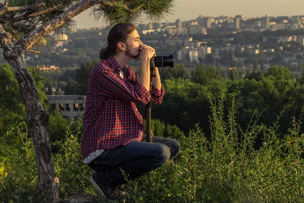 Мужской фотограф сидит с цифровой камерой . — стоковое фото
