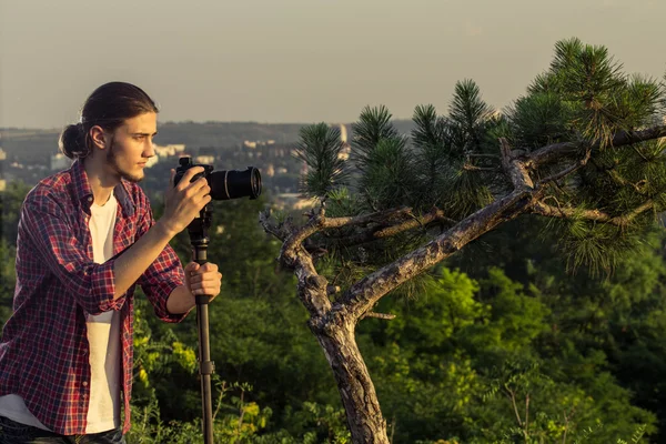 Fotografo maschio che scatta foto con fotocamera DSLR . — Foto Stock