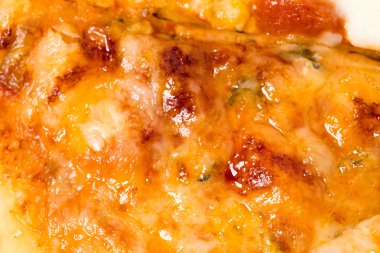 Dilimlenmiş pizza üzerinde eritilmiş peynir closeup.