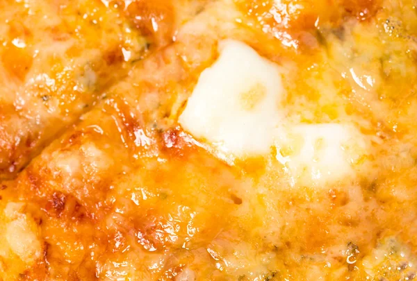 Nahaufnahme von geschmolzenem Käse auf aufgeschnittener Pizza. — Stockfoto