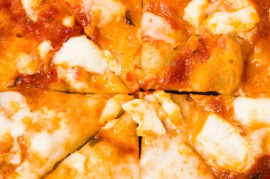 Dilimlenmiş pizza üzerinde eritilmiş peynir closeup.