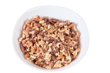 Soyulmuş cevizler yuvarlak bir tabakta. Beyaz arka planda izole edilmiş. Yakın plan..