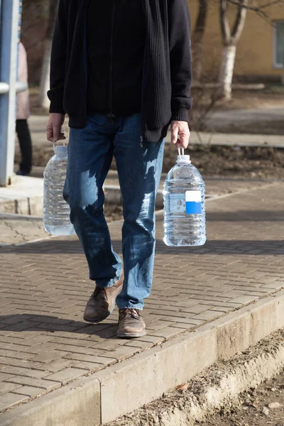 Hombre Lleva Dos Botellas Agua Potable Primer Plano —  Fotos de Stock