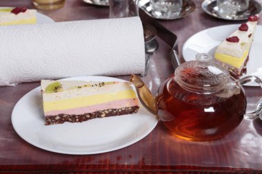 Çay ve çilekli cheesecake ile şeffaf çaydanlık. Yakın plan..