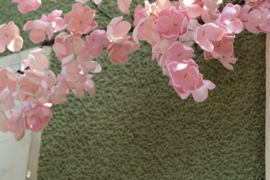 Duvarda kullanmak için yapay çiçekler var. Şehrin mimarisinde yeşil ve pembenin harika bir kombinasyonu..