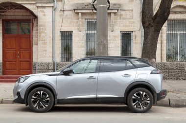 Kaldırımın kenarına park edilmiş bir araba. Şehirde bir araba. Yan görünüm.