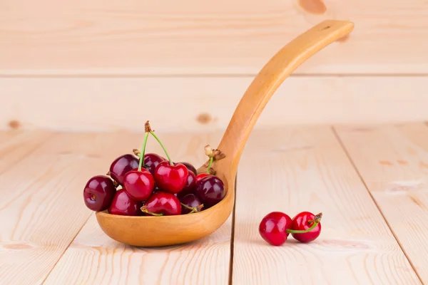 Cerezas frescas en cuchara de madera . — Foto de Stock