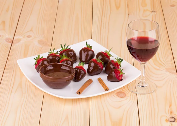 Strawberries in chocolate with cinnamon on wood. — Stock Photo, Image