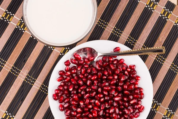 Milk and seeds of pomegranate — Stock Photo, Image