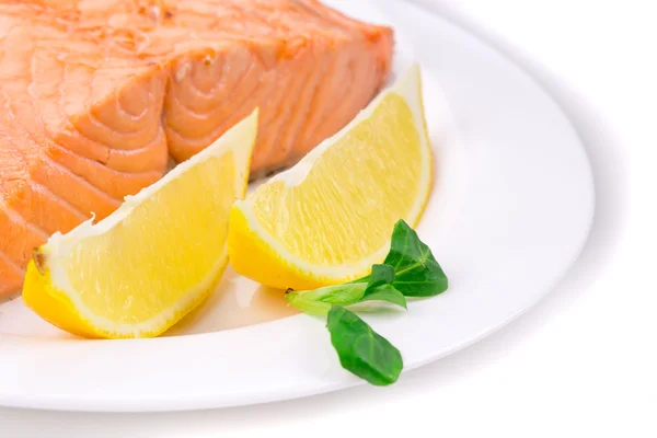 Филе жареного лосося на тарелке с лимоном . — стоковое фото
