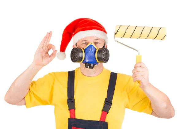 Worker in gas mask and santa hat with roller — Stock Photo, Image