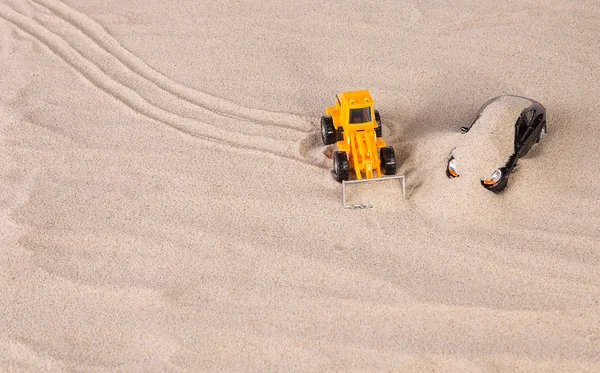 Loader and racing car on sand. — Stock Photo, Image