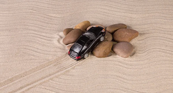 Negro coche de carreras en un montón de piedras — Foto de Stock