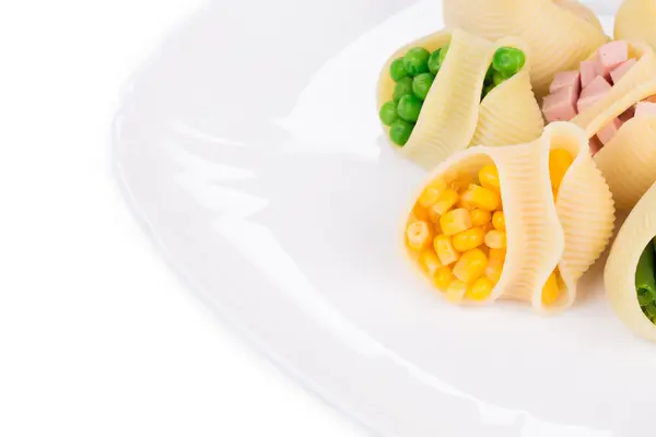 Паста раковины фаршированные овощами и колбасой — стоковое фото
