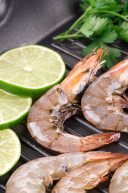 Raw shrimps on pan clipart