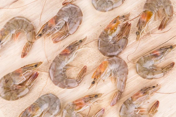 Gamberetti crudi su piatto di legno . — Foto Stock