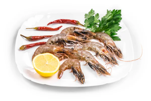 Raw shrimps on plate with lettuce and lemon. — Stock Photo, Image
