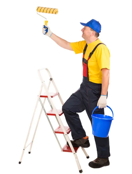 Trabajador en escalera con rodillo y cubo . — Foto de Stock