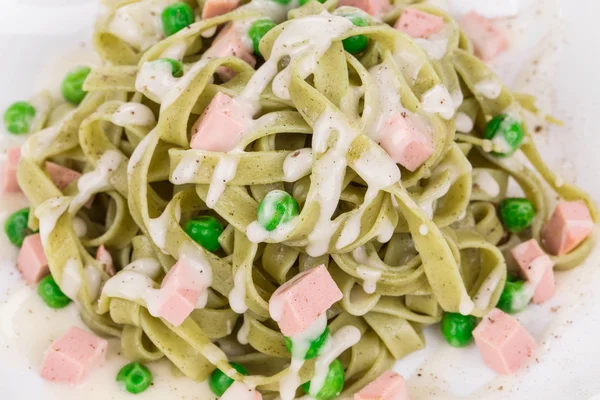 Pasta tagliatelle with green peas and ham. — Stock Photo, Image