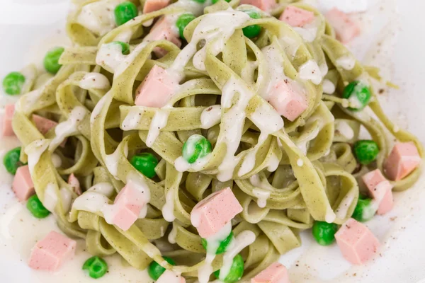 Tagliatelles de pâtes aux pois verts et jambon . — Photo