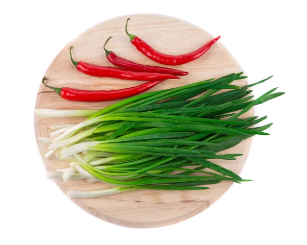 Green onion and pepper on wooden platter. — Stock Photo, Image