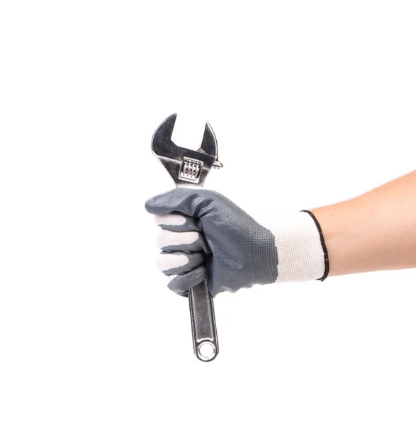 Hand in gloves holding adjustable wrench. — Stock Photo, Image