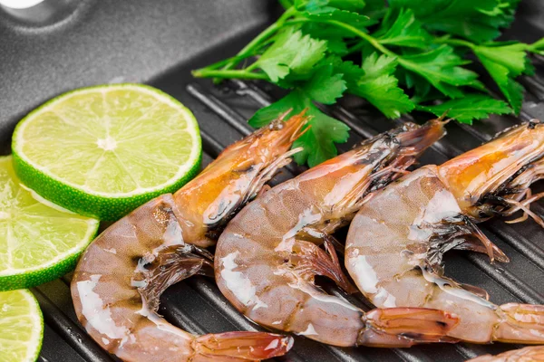 Raw shrimps on black pan. — Stock Photo, Image