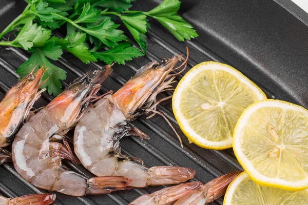 Raw shrimps on black pan. — Stock Photo, Image
