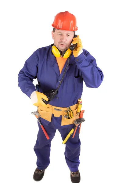 Worker in blue overalls talking on the phone. — Stock Photo, Image