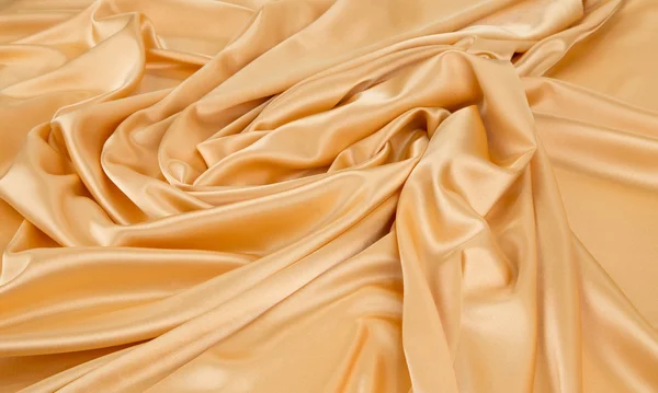 Gouden zijden doek close-up. — Stockfoto