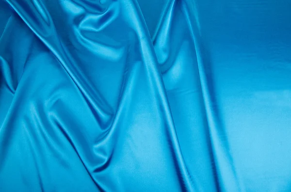 Światło niebieskie fałdy jedwab tekstura tkanina. — Zdjęcie stockowe