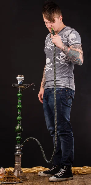 纹身的男子吸烟传统水烟. — 图库照片