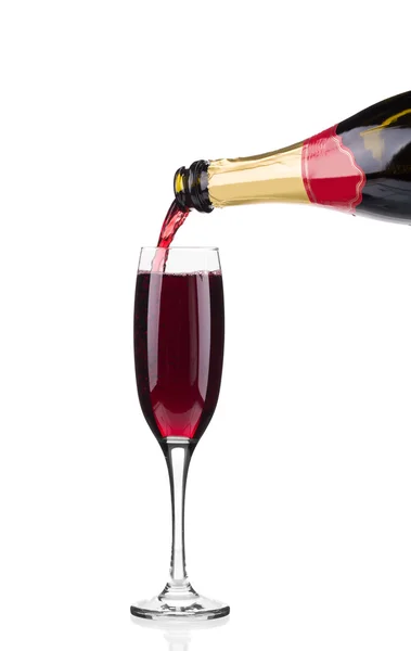 Rode gieten in een glas champagne. — Stockfoto