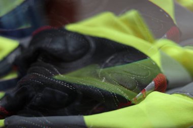 Yansıtıcı yeleğin üzerindeki deri bisiklet eldiveni. Bu görüntü soyut ve bulanık. Yakın plan..