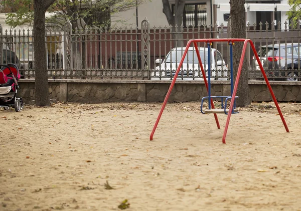 Kinderschaukel auf sandigem Spielplatz — Stockfoto
